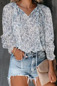 Detailed view of women's bohemian floral print blouse with V-neck tie and ruffled cuffs