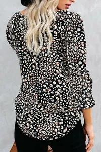 Back view detail of leopard print long sleeve shirt with ruffled cuffs and curved hem.