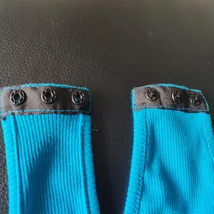 Detail view of the secure bottom snap button closure on a blue ribbed long sleeve bodysuit