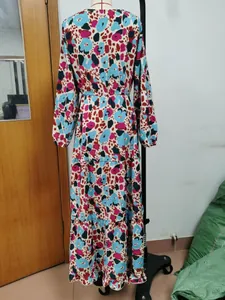 Back view of bohemian tiered maxi dress with colorful abstract print on mannequin