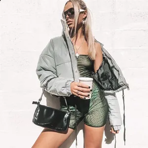 Stylische graue Crop-Pufferjacke kombiniert mit grünem Mesh-Body und schwarzer Tasche