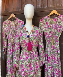 Vue détaillée d'une robe longue bohème à col en V avec motifs floraux roses et verts.