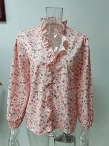 Dettaglio di camicetta floreale a maniche lunghe con collo a volant e stampa rosa.