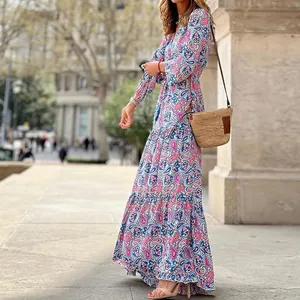 Vue latérale d'une robe maxi bohème à fleurs portée avec un sac en paille printanier