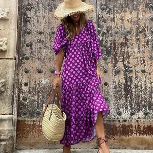 Nahaufnahme eines lila Maxikleids mit geometrischem Muster und eleganten Puffärmeln