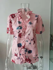 Dettaglio di una camicetta rosa da donna con volant e stampa floreale per l'estate