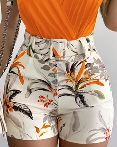 Detailed view of high-waisted floral shorts and orange wrap top with matching belt.