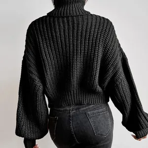 Rückansicht eines schwarzen grob gestrickten Rollkragenpullovers mit Ballonärmeln.