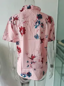 Vista posteriore dettagliata di una camicetta rosa da donna con motivo floreale e colletto a balze