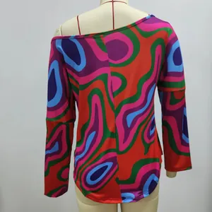 Detailed view of the vibrant psychedelic geometric print on this off-shoulder long sleeve top