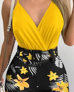 Close-up of vibrant yellow V-neck camisole and tropical floral print shorts set with belt