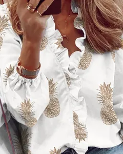 Dettaglio camicia bianca a maniche lunghe con stampa ananas dorata e volant