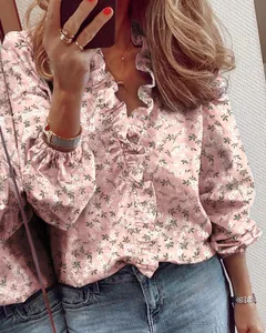 Dettaglio camicetta floreale rosa con bordi a balze ed eleganti polsini elastici