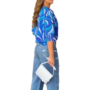 Close-up detail of women's loose fit blouse featuring a blue geometric swirl print