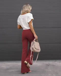 Back view of women's burgundy high waist corduroy flare pants with white knit top