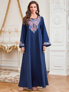 Elegante marineblauwe maxi-jurk met lange mouwen, levendig bloemmotief en kralen.