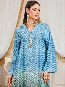 Detail view of blue wave print kaftan dress with V-neck and decorative tassel detail