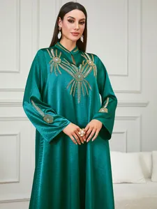 Detalle del vestido caftán verde esmeralda con elegantes bordados dorados y cuentas