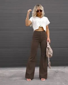 Outdoor lifestyle shot of high-waist brown corduroy flare pants with a white top