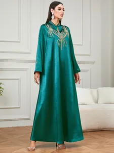 Primer plano de un elegante vestido étnico verde esmeralda con bordados dorados