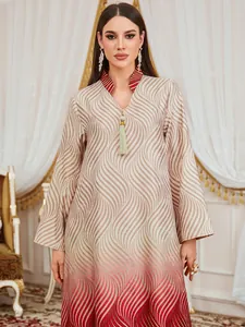 Elegant V-neck dress with digital wave print and tassel detail shown in close-up shot.