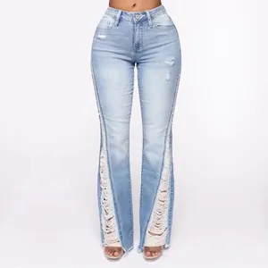 Detail of light blue high-waisted ripped flare jeans with distressed fringed hems