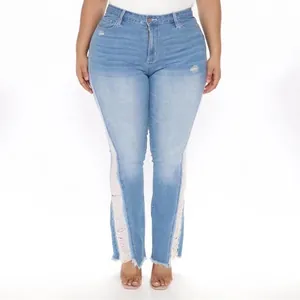 Detail view of plus size light blue distressed flared denim jeans with a frayed hem