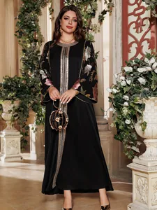 Detail showing the intricate sequin floral embroidery on the black kaftan dress sleeve.