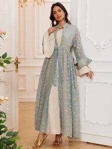 Elegante abito lungo blu ricamato con maniche a campana e sottoveste crema abbinata.