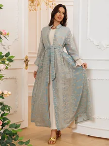 Elegante set di due pezzi con un caftano ricamato azzurro sopra un abito lungo color crema.
