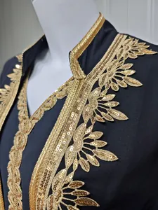 Detailaufnahme der goldenen Paillettenstickerei am Ausschnitt des schwarzen Kleides
