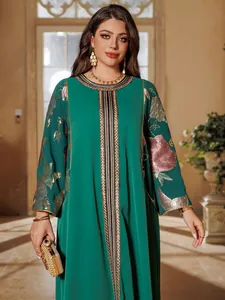 Close-up detail view of emerald green kaftan dress with pink floral sequin embroidery