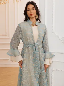 Dettaglio dell'elegante set composto da cardigan ricamato celeste e abito lungo.
