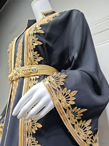 Detailaufnahme der komplizierten Goldstickerei und Pailletten auf einer schwarzen Abaya.