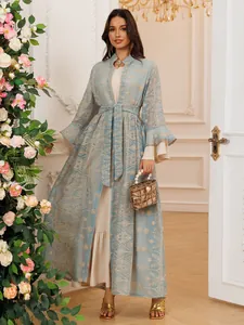 Elegante set di cardigan lungo ricamato azzurro con maniche a campana e abito beige.