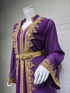 Detailansicht eines lila Kaftans mit aufwendiger Goldstickerei und passendem Gürtel