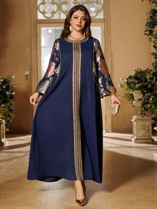 Detailed view of dark blue kaftan dress with gold sequin embroidery and floral sleeves