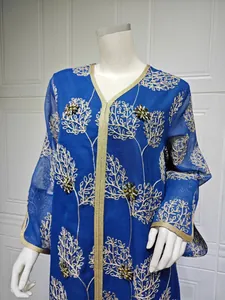 Close-up of blue mesh dress with gold embroidery and handmade beadwork detail.