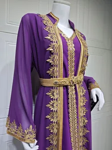 Detailaufnahme eines lila Kaftan-Kleides mit exquisiter goldener Blattstickerei