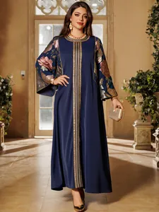 Detailed view of navy blue long dress with floral sequins and gold embroidery.