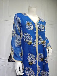 Detailed macro shot of an elegant blue mesh dress with gold embroidery and beads