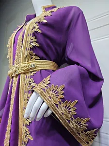 Detailansicht eines lila Kaftans mit goldener Stickerei und passendem Taillengürtel.