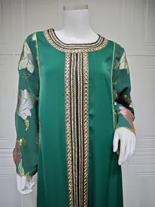 Detail view of green elegant dress with gold sequin embroidery and mirror accents.