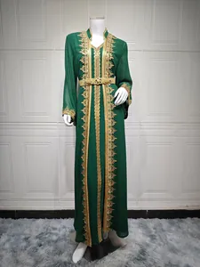 Elegantes smaragdgrünes Kaftan-Kleid mit goldener Stickerei auf einer Schaufensterpuppe.