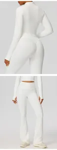 Gedetailleerde opname van een witte yogaset met een getailleerd jasje en uitlopende broek.