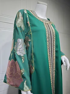 Close-up of exquisite sequin flower embroidery on elegant green long kaftan dress