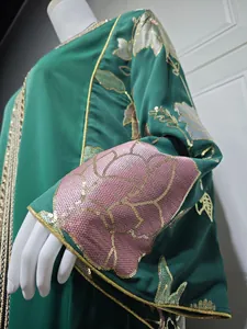Detail of green long dress sleeve with pink and gold floral sequin embroidery
