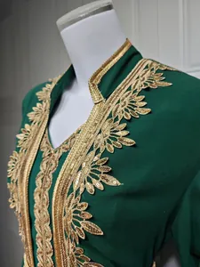 Makrodetail der Goldstickerei und Pailletten an einem dunkelgrünen marokkanischen Kaftan
