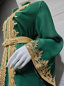 Detailansicht der Goldstickerei auf dem Ärmel und Gürtel des dunkelgrünen marokkanischen Kleides.