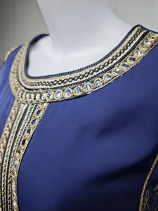 Detailed macro view of intricate gold embroidery and sparkling sequins on a royal blue dress